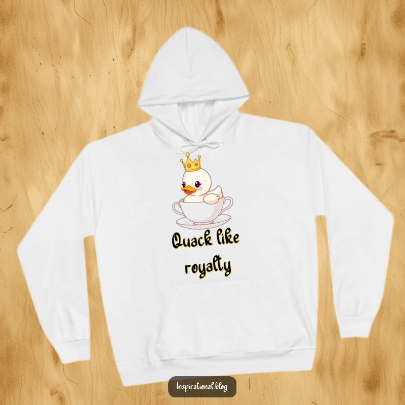 Funny hoodie depicting a rubber duck with a tiny crown, floating serenely on a teacup, offering warmth and comical regality.