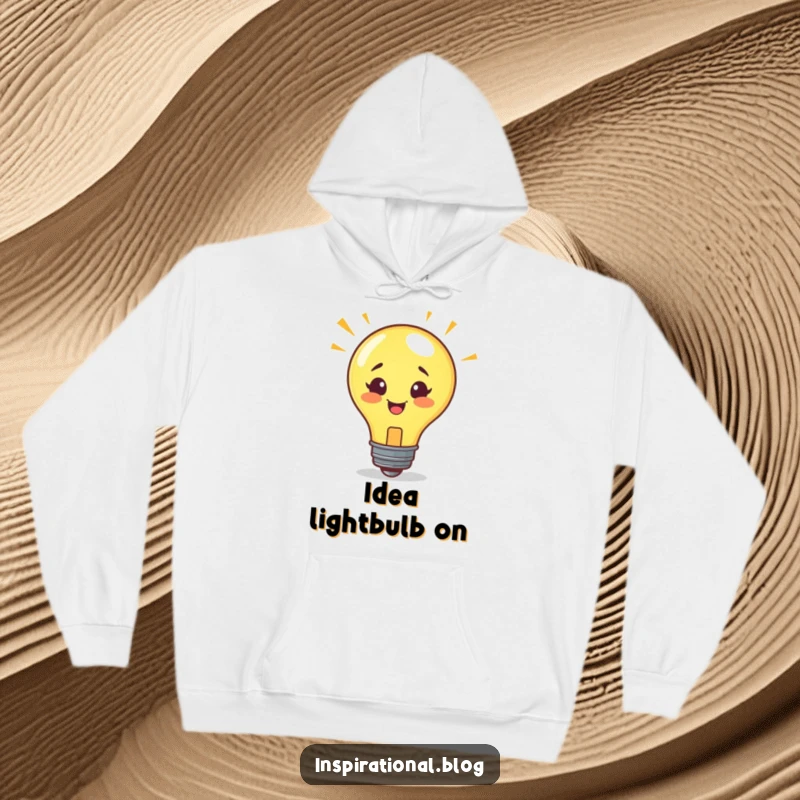 Funny hoodie showcasing a smiling lightbulb character bursting with a new, brilliant idea, ideal for cozy brainstorming.